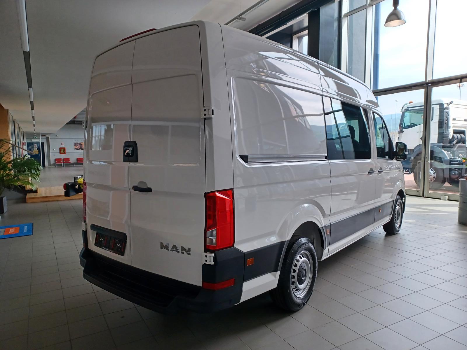 Furgone MAN bianco in un edificio ben illuminato.