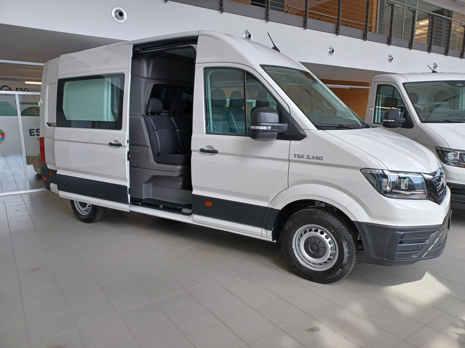 Un furgone bianco Volkswagen Crafter con la porta laterale scorrevole aperta.