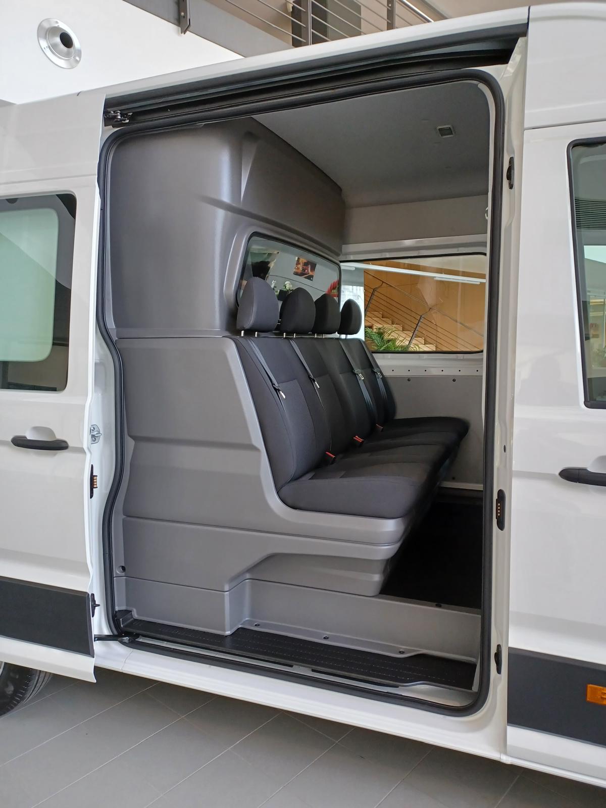 Interni di un furgone bianco con sedili.