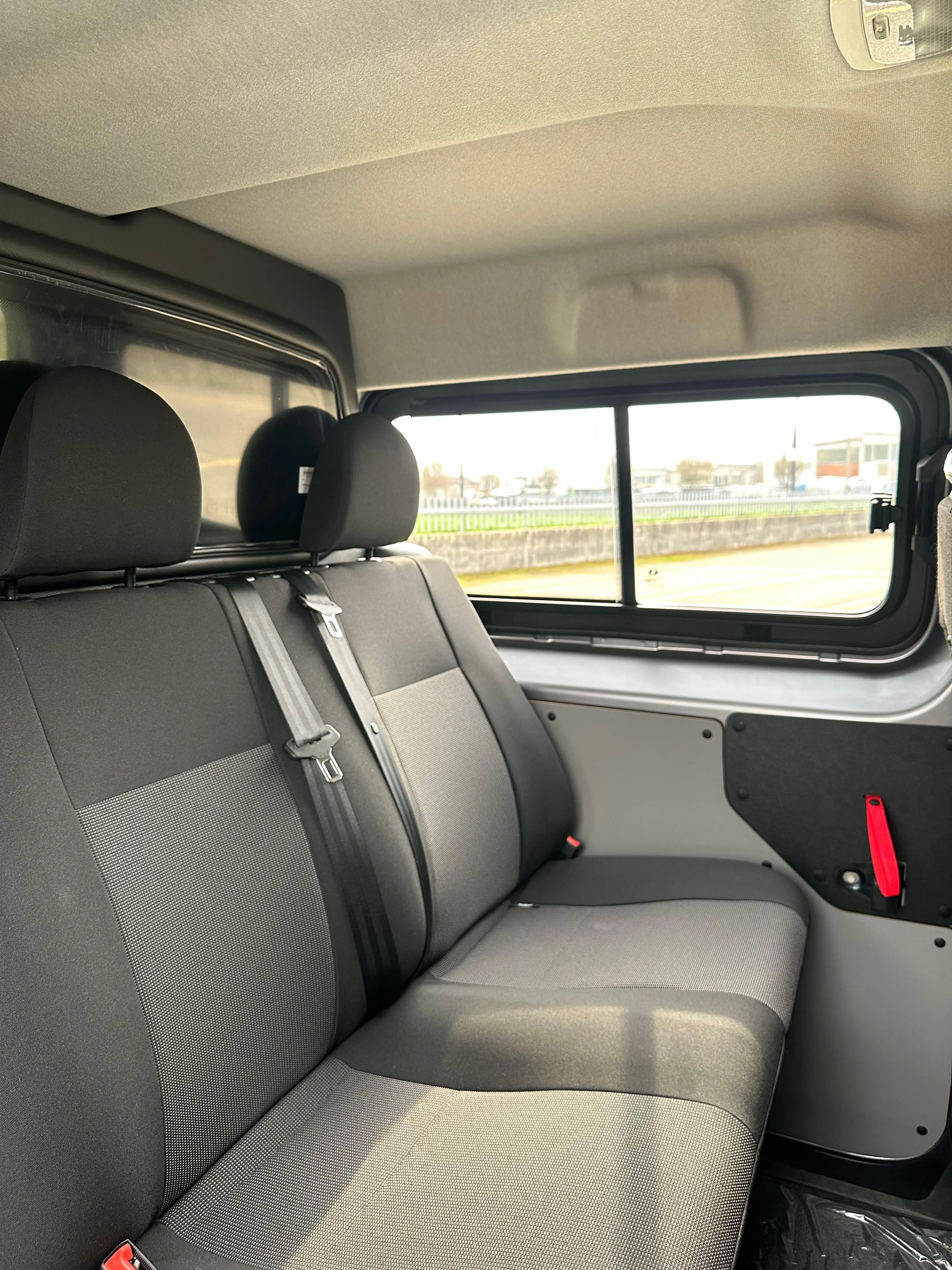 Interni di un veicolo con sedili grigi.