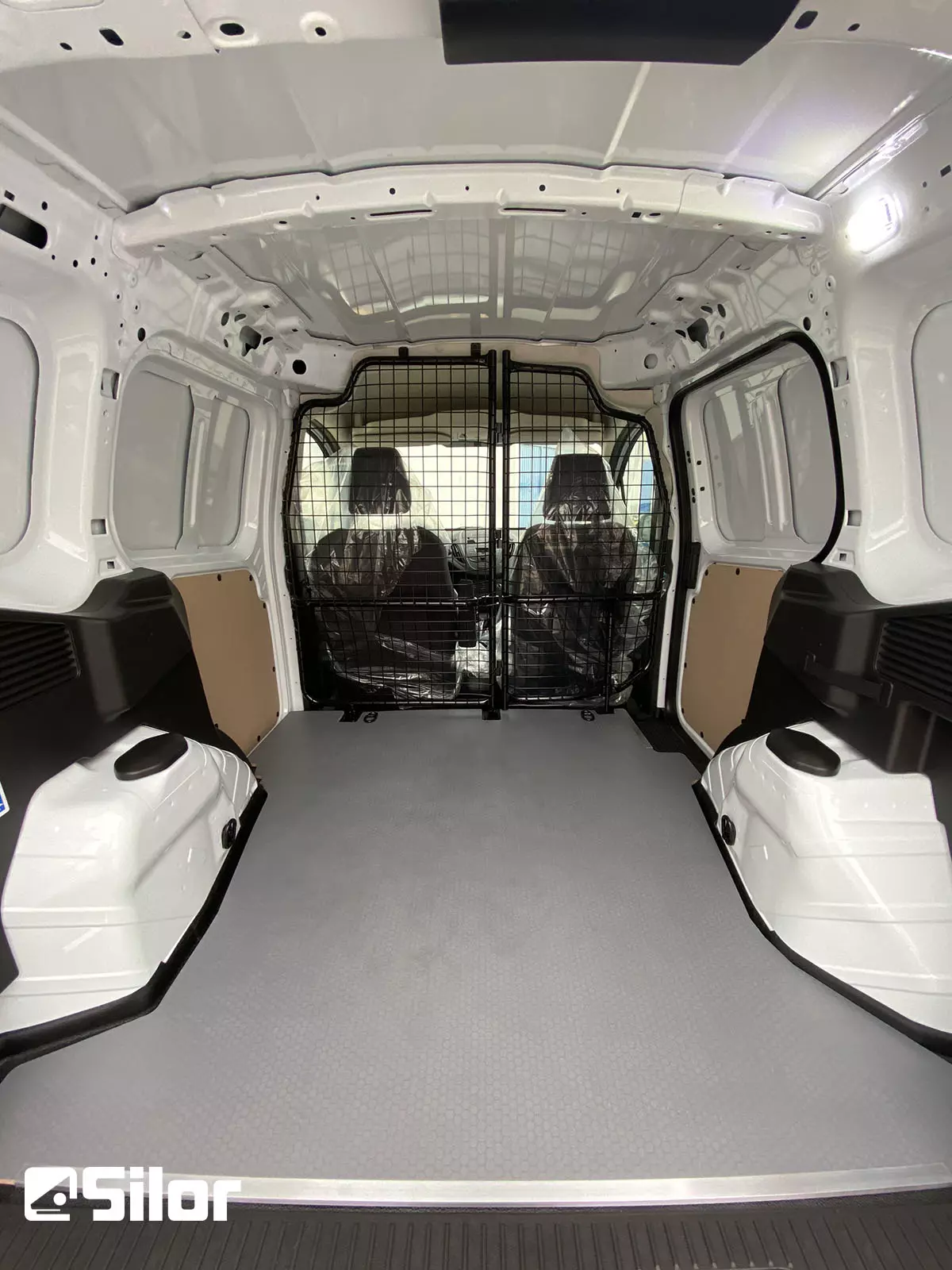 Interni di furgone bianco con divisorio a griglia.