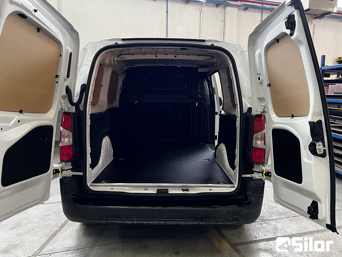 Interno di un furgone bianco con le porte posteriori aperte.