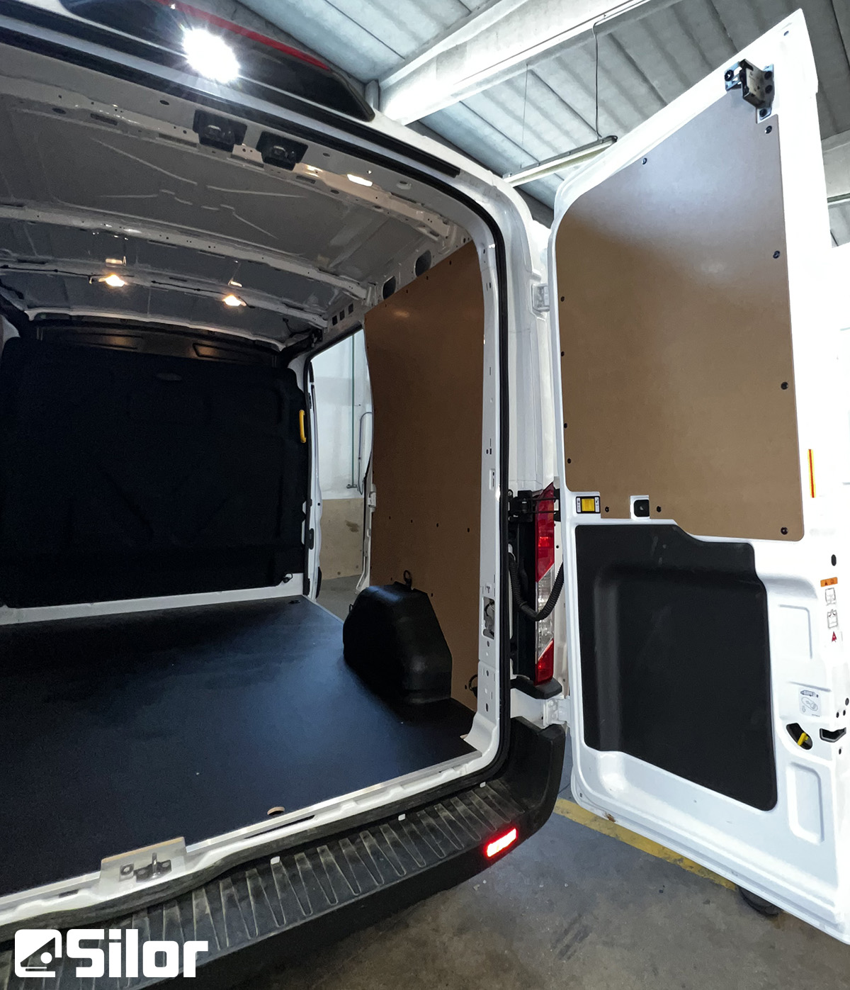 Interno di un furgone bianco con porte posteriori aperte.