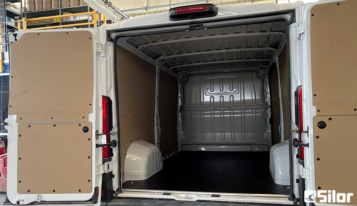 Interni di un furgone bianco con porte posteriori aperte.