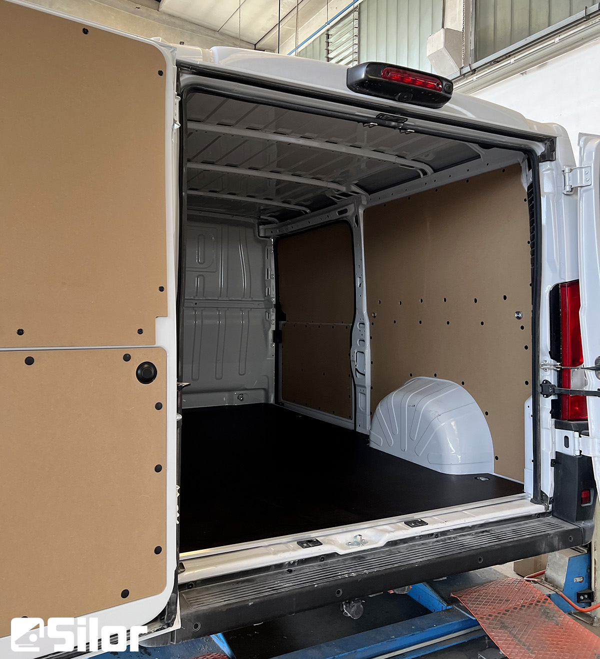 Interni di un furgone commerciale, parzialmente rivestito in legno.