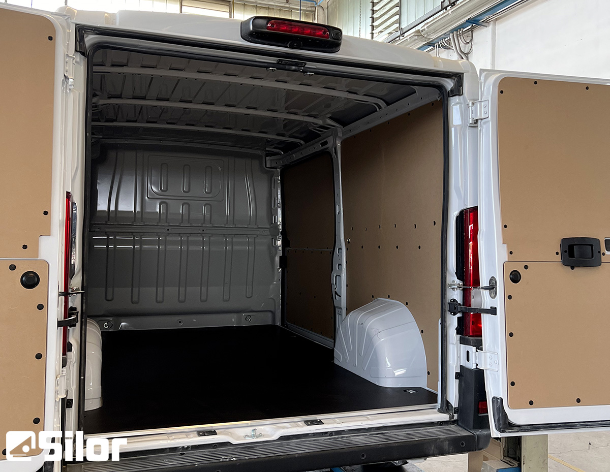 Interno di un furgone bianco con portellone posteriore aperto.