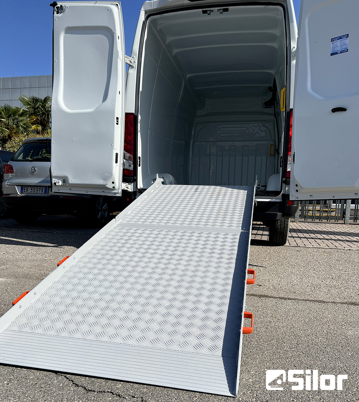 Furgone bianco con rampa di carico aperta.