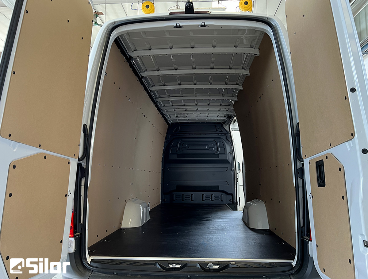 Interni di furgone cargo bianco con scaffalature interne in legno.