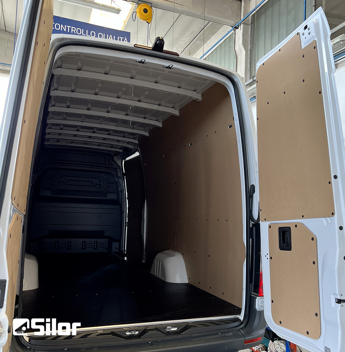 Interni di un furgone bianco rivestito in legno.