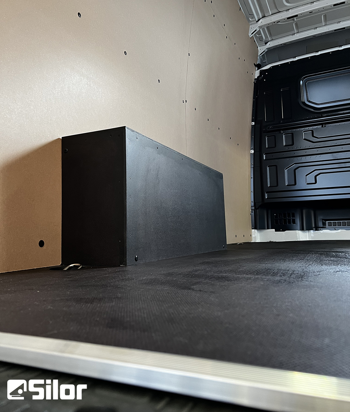 Interno di un furgone con pannelli, pavimentazione in gomma nera e box.
