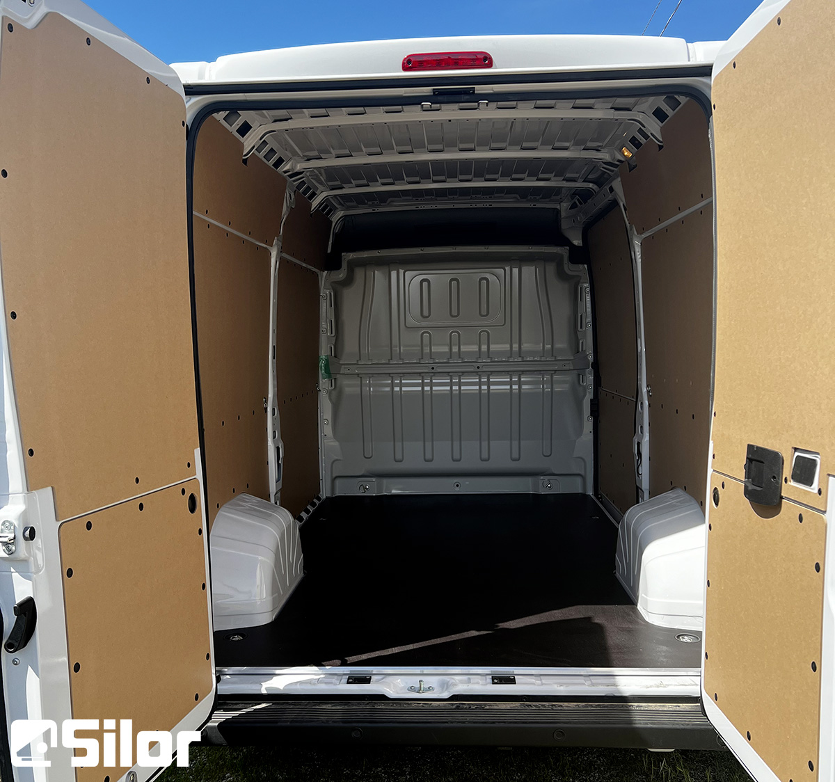 Interni di un furgone merci bianco con le porte posteriori aperte.