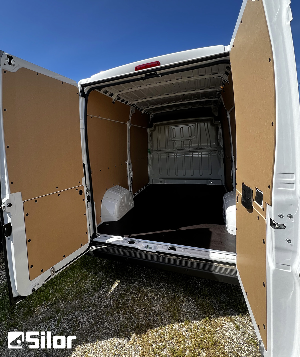 Interni di un furgone bianco con le portiere posteriori aperte.