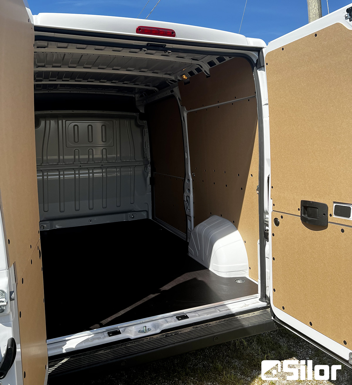 Interni spaziosi di un furgone bianco con rivestimenti in legno.