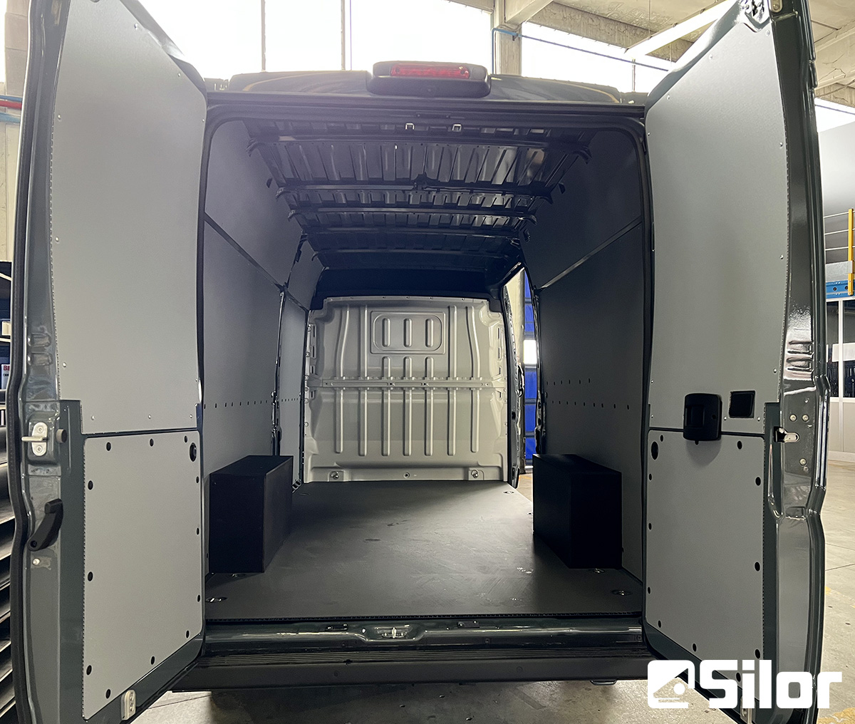 Interni di un furgone merci con porte posteriori aperte.