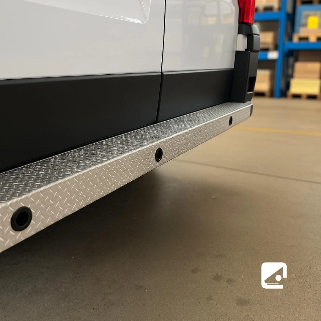 Il robusto paraurti diamantato in metallo conferisce a questo furgone bianco un aspetto resistente.