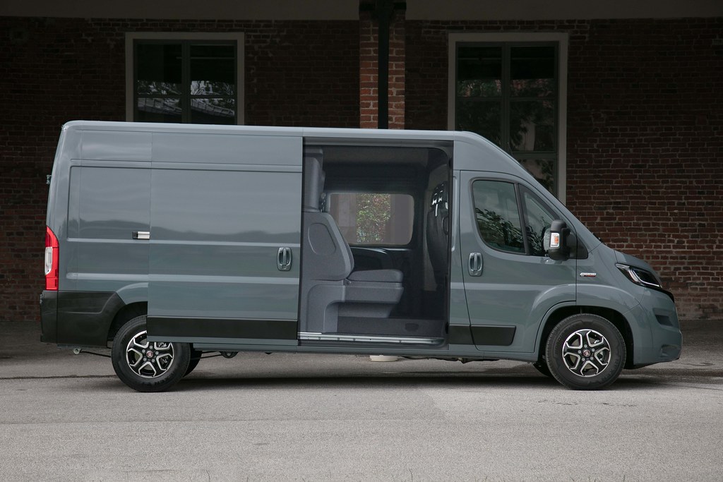 Un camion moderno con cassone versatile, metà chiuso e metà a gabbia, pronto per ogni carico.