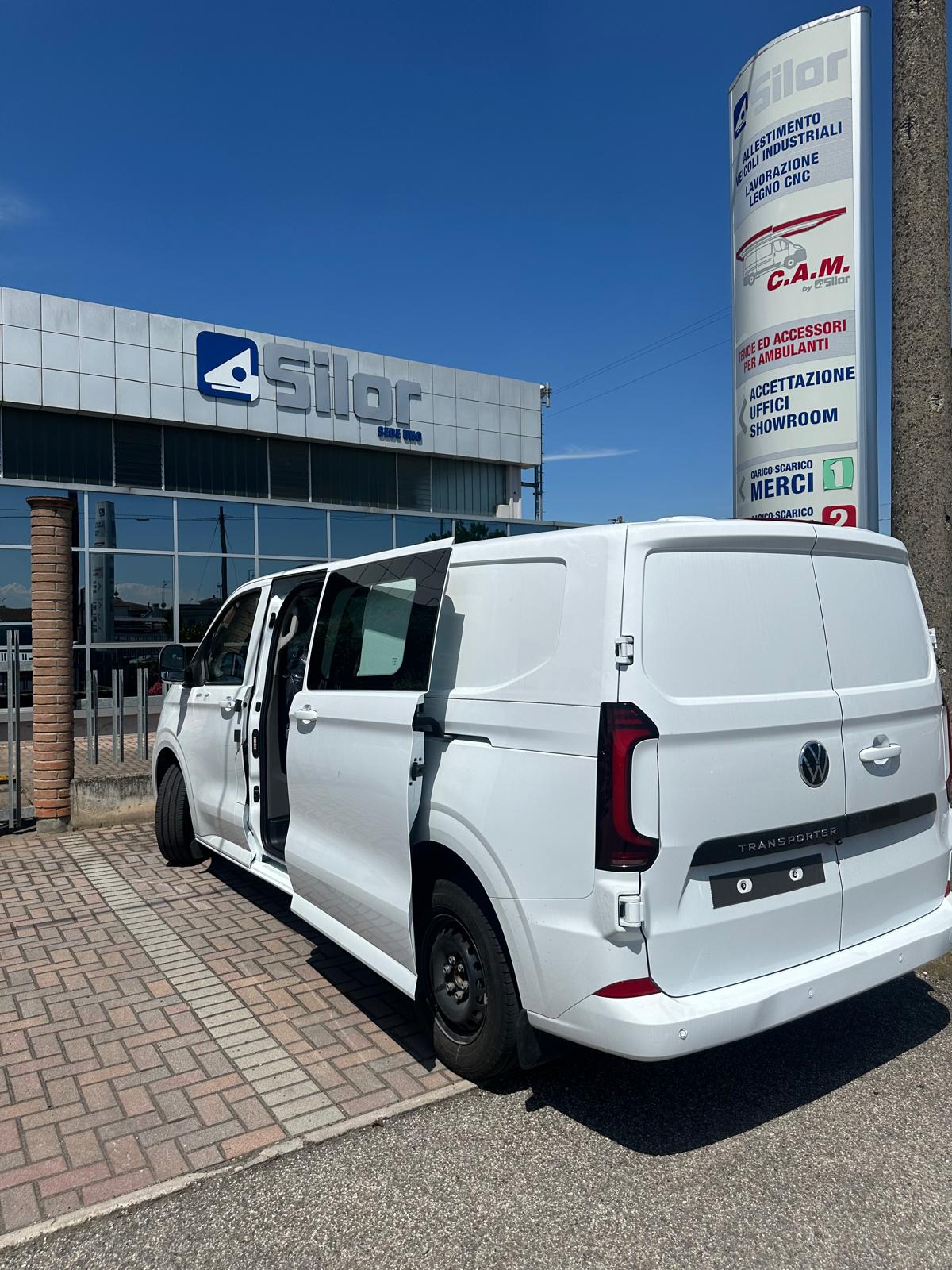Furgone Volkswagen Transporter bianco con porte aperte davanti alla Silor, azienda di allestimenti veicoli industriali.