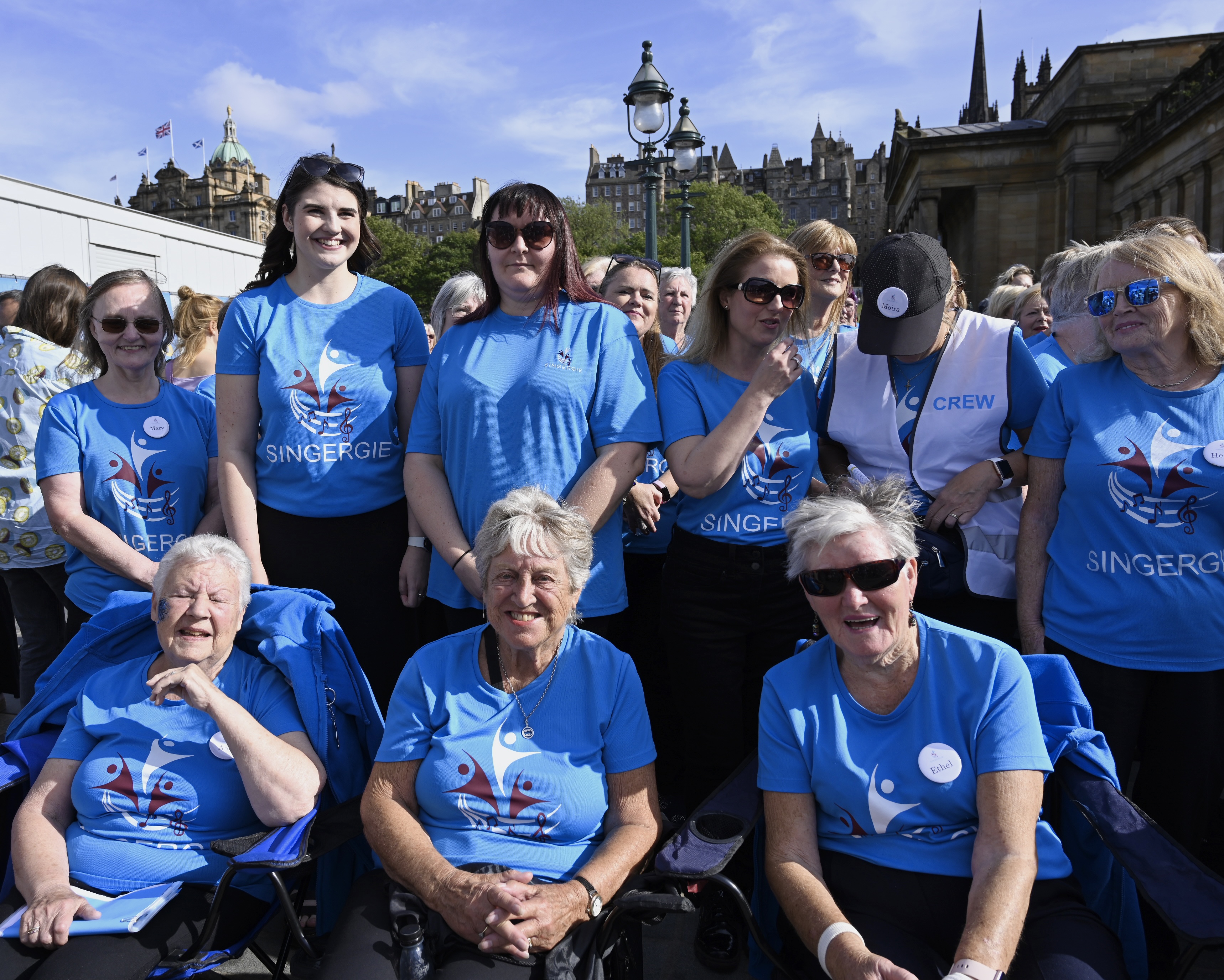A friendly community choir gathered in a circle, laughing before rehearsal starts