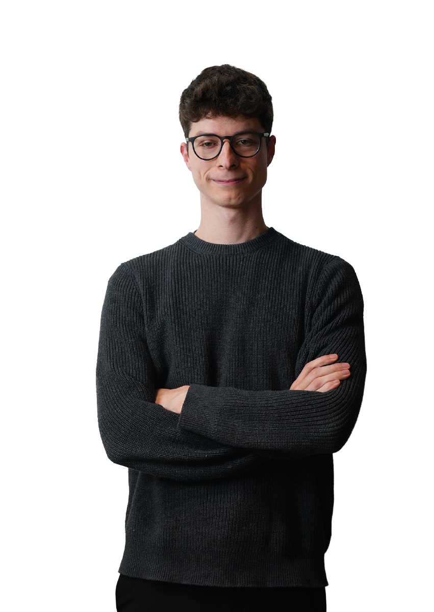 Un uomo che indossa gli occhiali, con le braccia conserte, su sfondo nero.