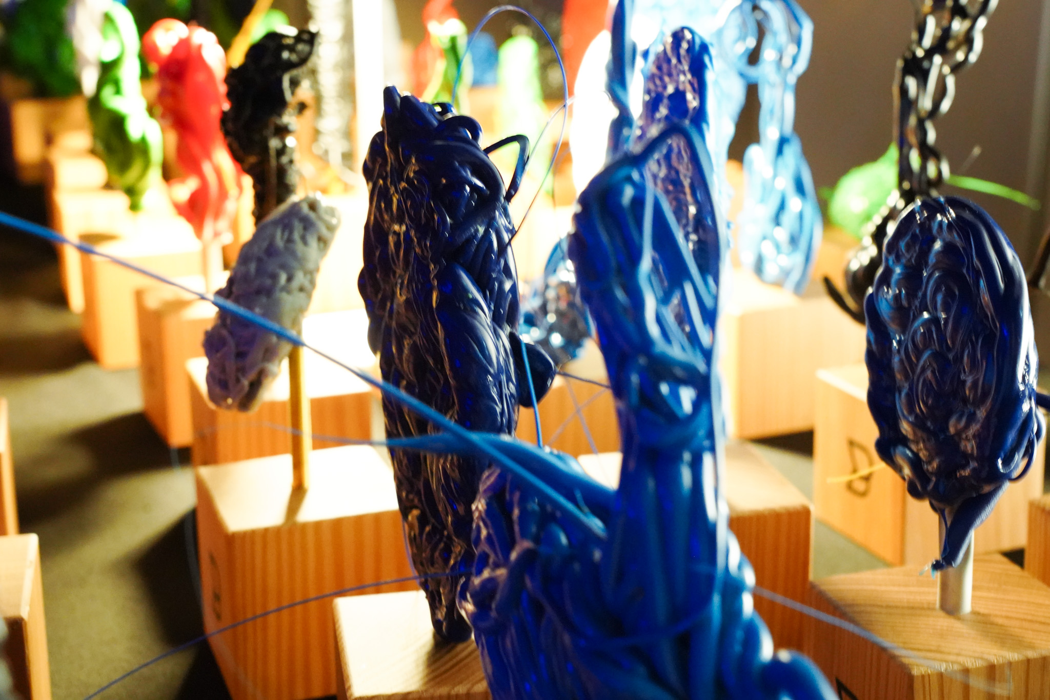 Sculture colorate su piedistalli di legno.
