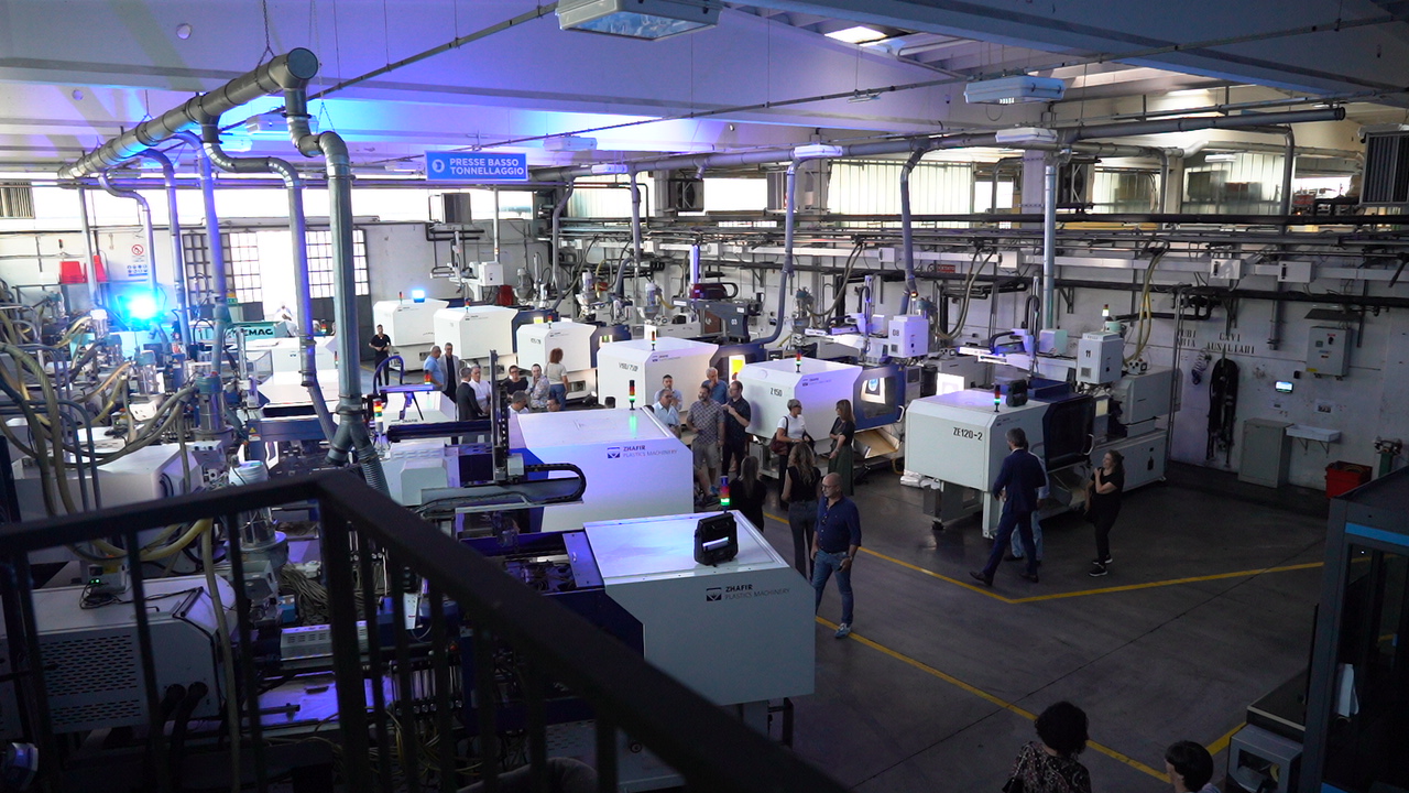 Tour di fabbrica con macchinari all'avanguardia e visitatori interessati.