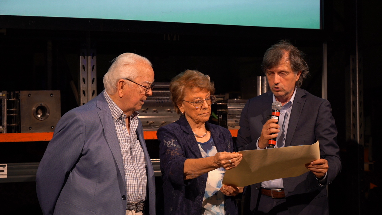 Tre persone che guardano un documento a un evento.