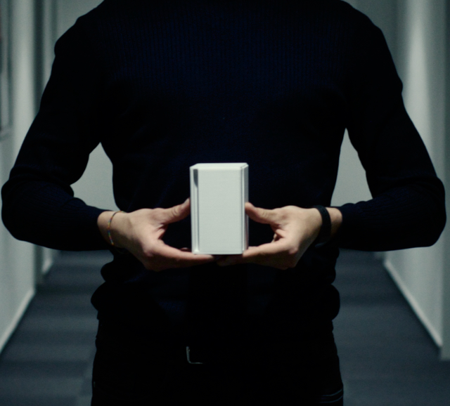The compact IoT sensor seamlessly blends into a modern office workspace, discreetly monitoring indoor air quality, temperature, and humidity levels to promote a healthy and productive environment for employees