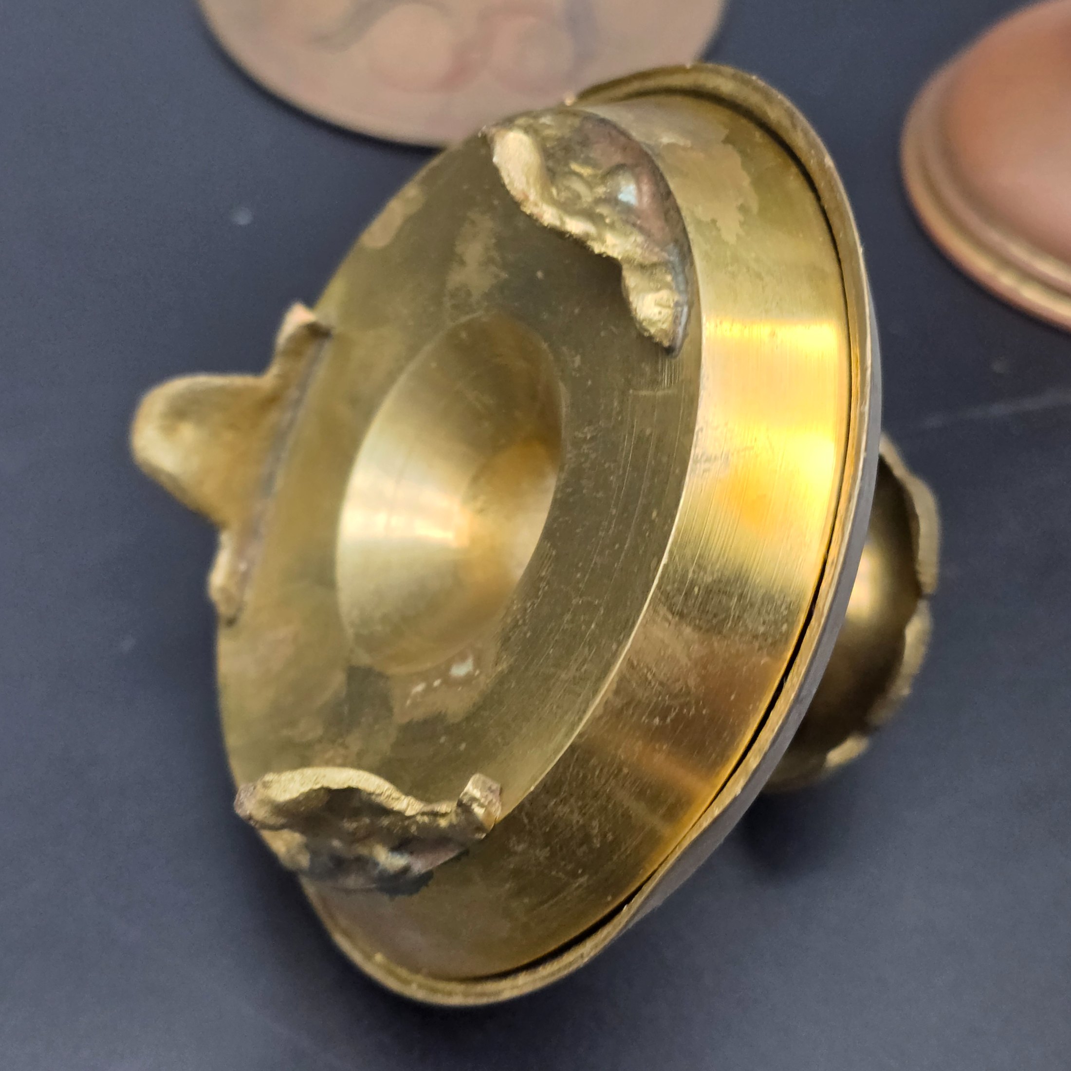 A curated collection of vintage decorative brass items, likely from the mid-20th century, featuring various engraved, enameled, and glazed finishes. - View 5