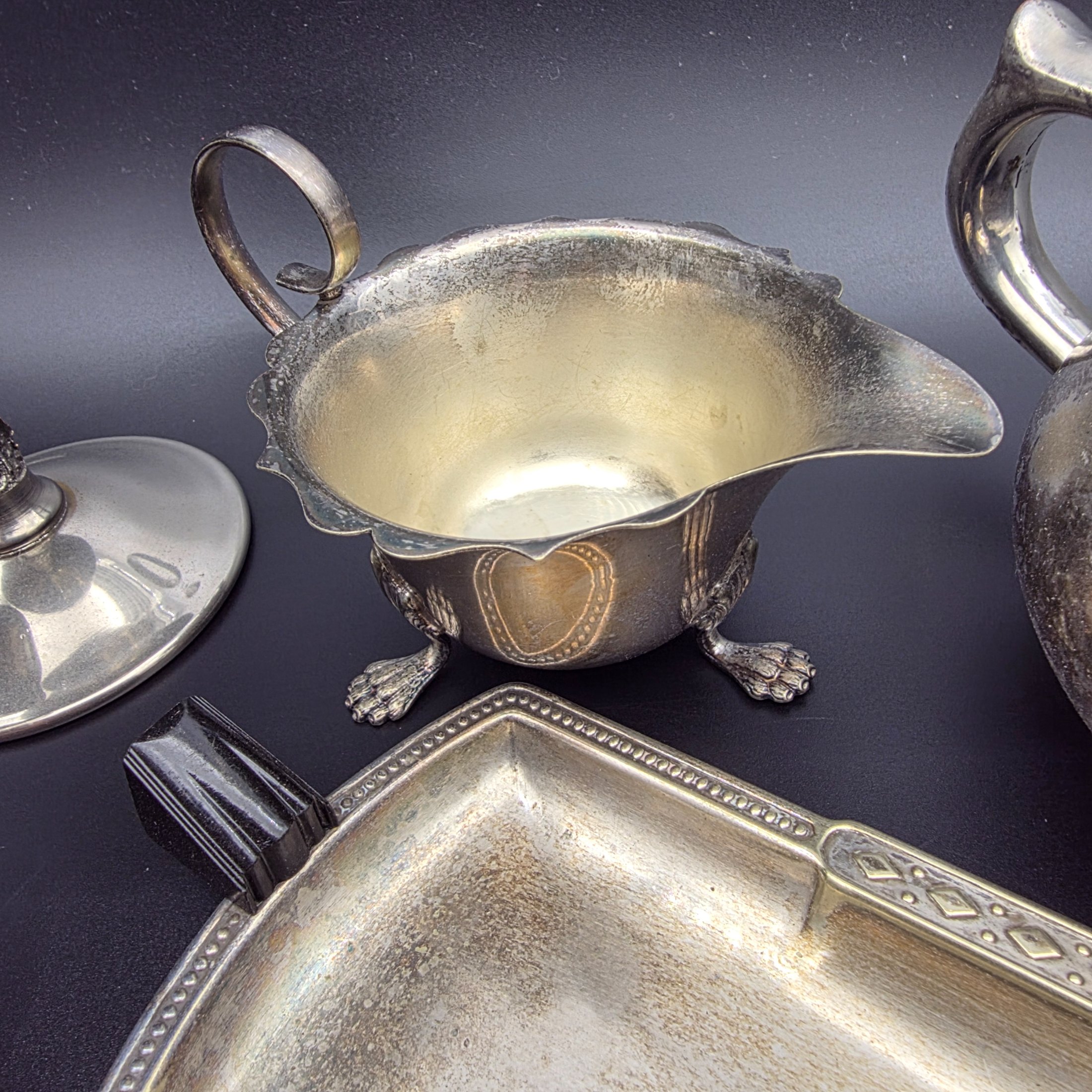 A varied collection of vintage F.B. Rogers silverplate items, including a compote, teapot, cream jug, sugar bowl, vase, goblet, and various trays, all showing signs of age and tarnishing. - View 7