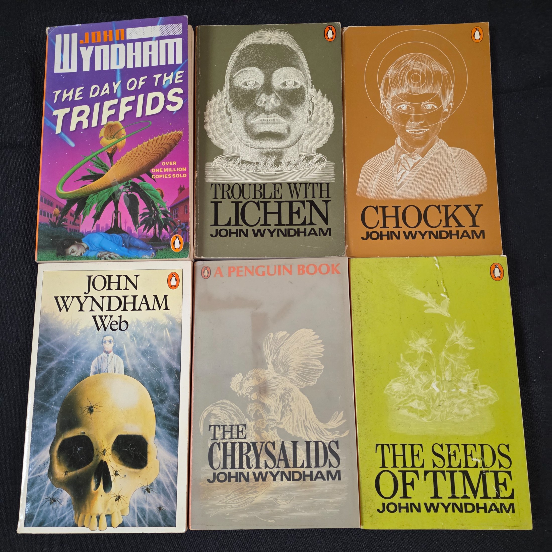 A collection of six vintage paperback science fiction novels by John Wyndham, featuring classic Penguin cover art.