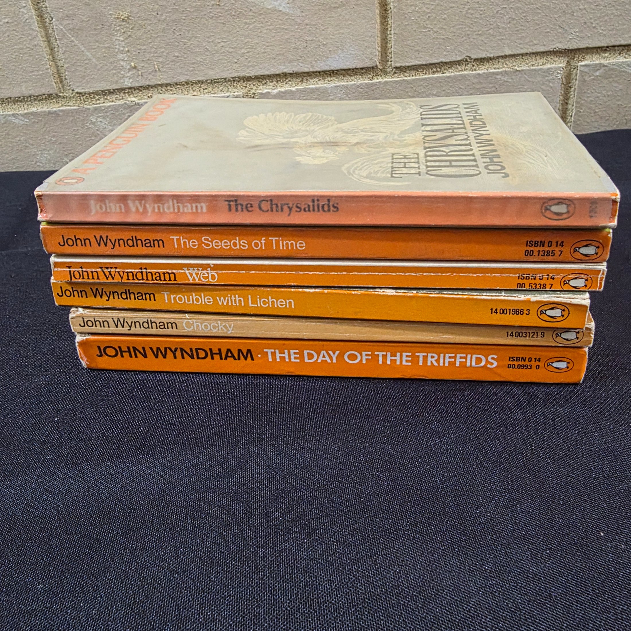 A collection of six vintage paperback science fiction novels by John Wyndham, featuring classic Penguin cover art. - View 4