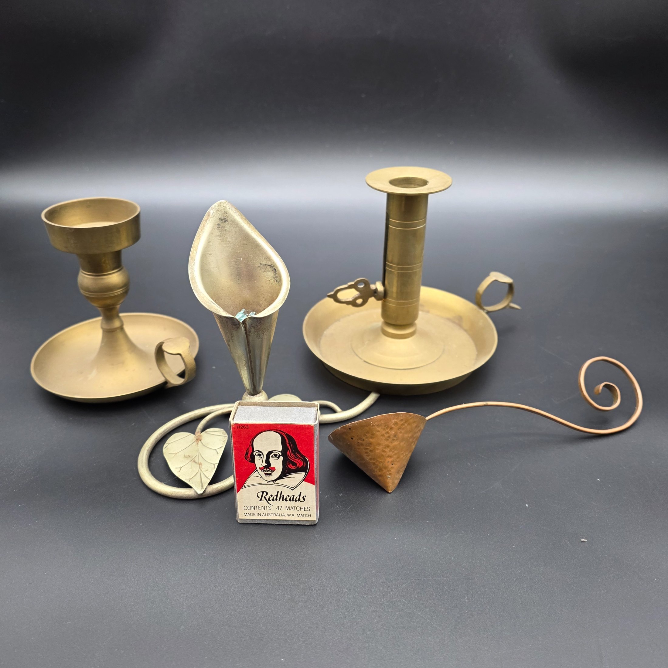 A lot of vintage brass and copper candle accessories, including two candlesticks and a decorative taper holder with an attached snuffer, likely dating from the early to mid-20th century. - View 2