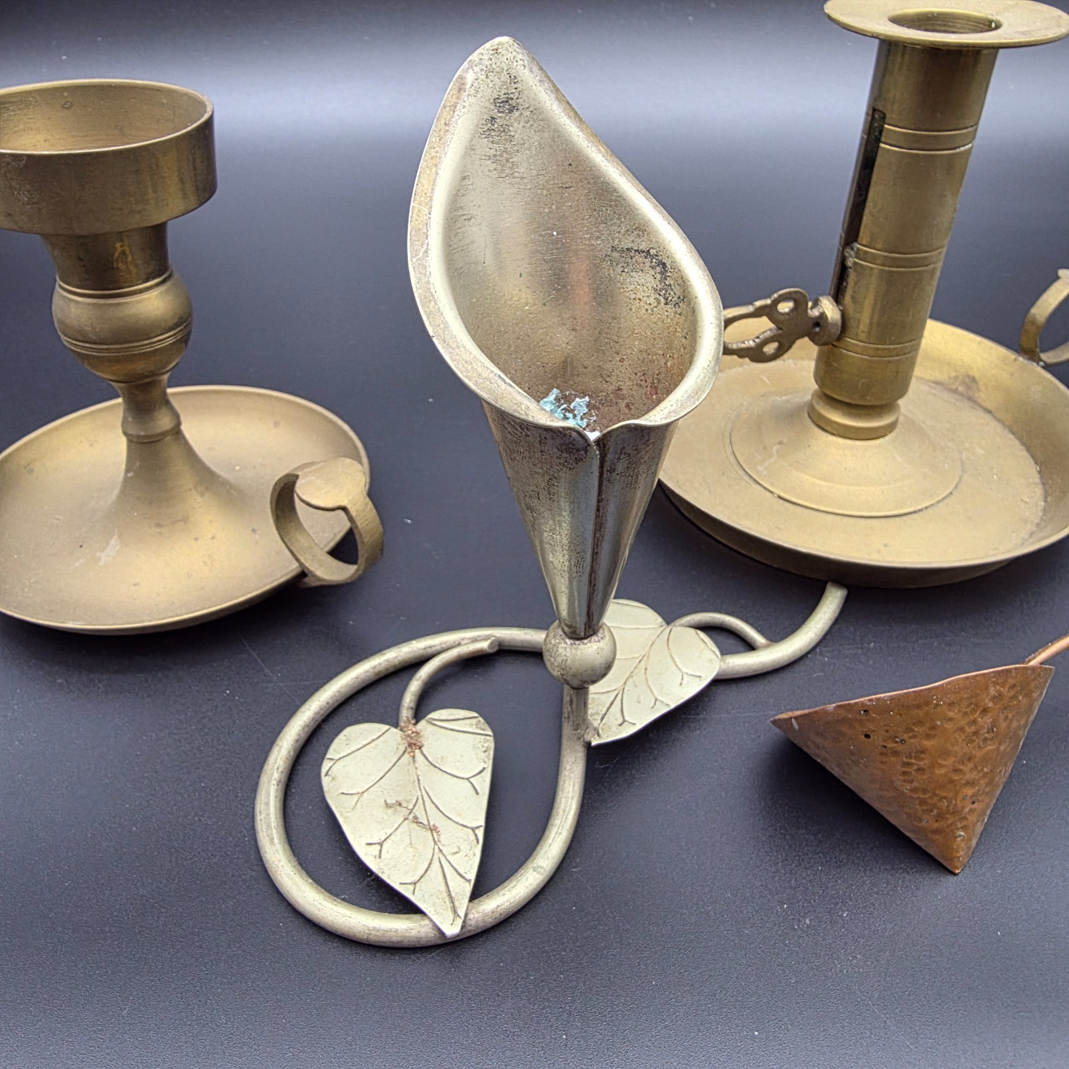 A lot of vintage brass and copper candle accessories, including two candlesticks and a decorative taper holder with an attached snuffer, likely dating from the early to mid-20th century. - View 3