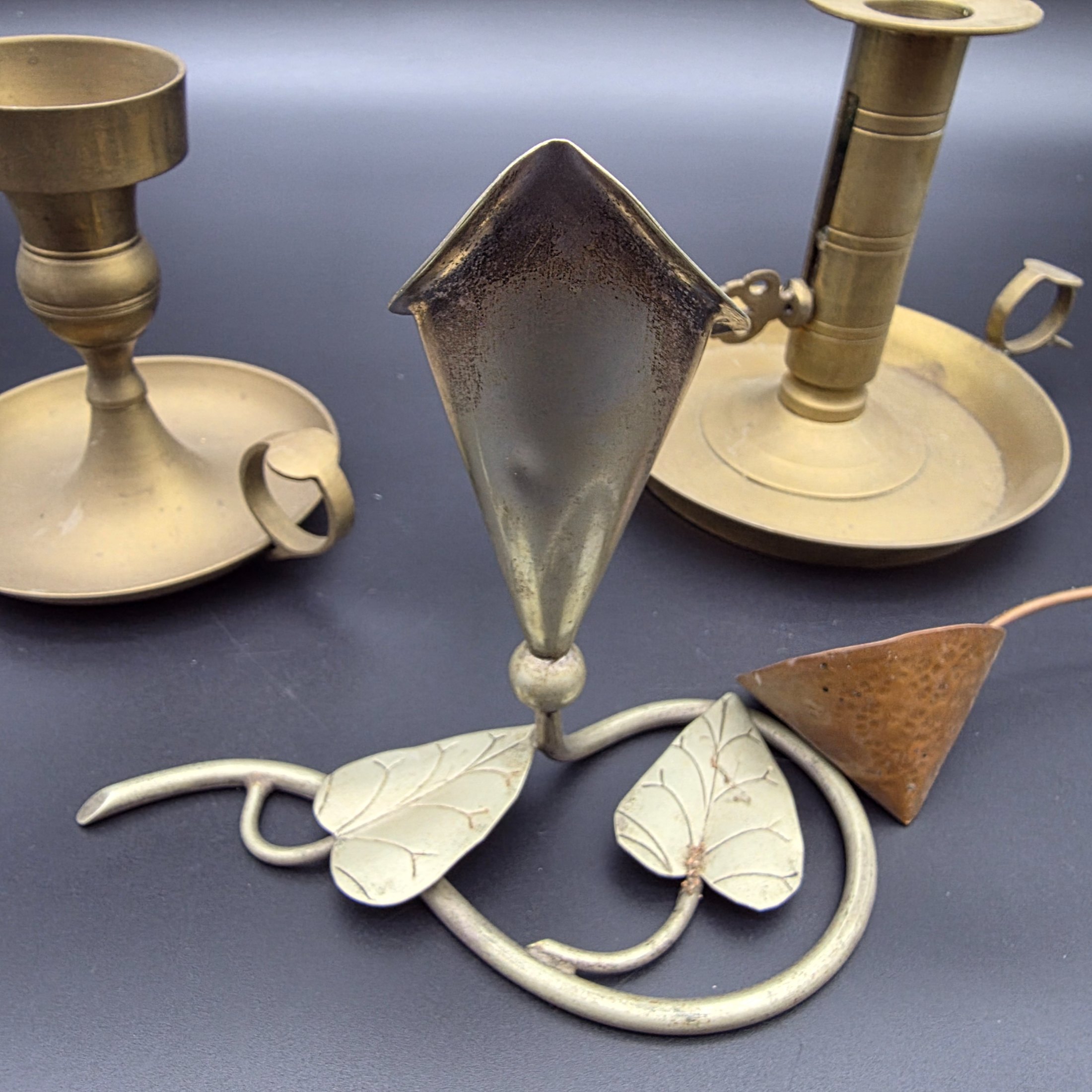 A lot of vintage brass and copper candle accessories, including two candlesticks and a decorative taper holder with an attached snuffer, likely dating from the early to mid-20th century. - View 4