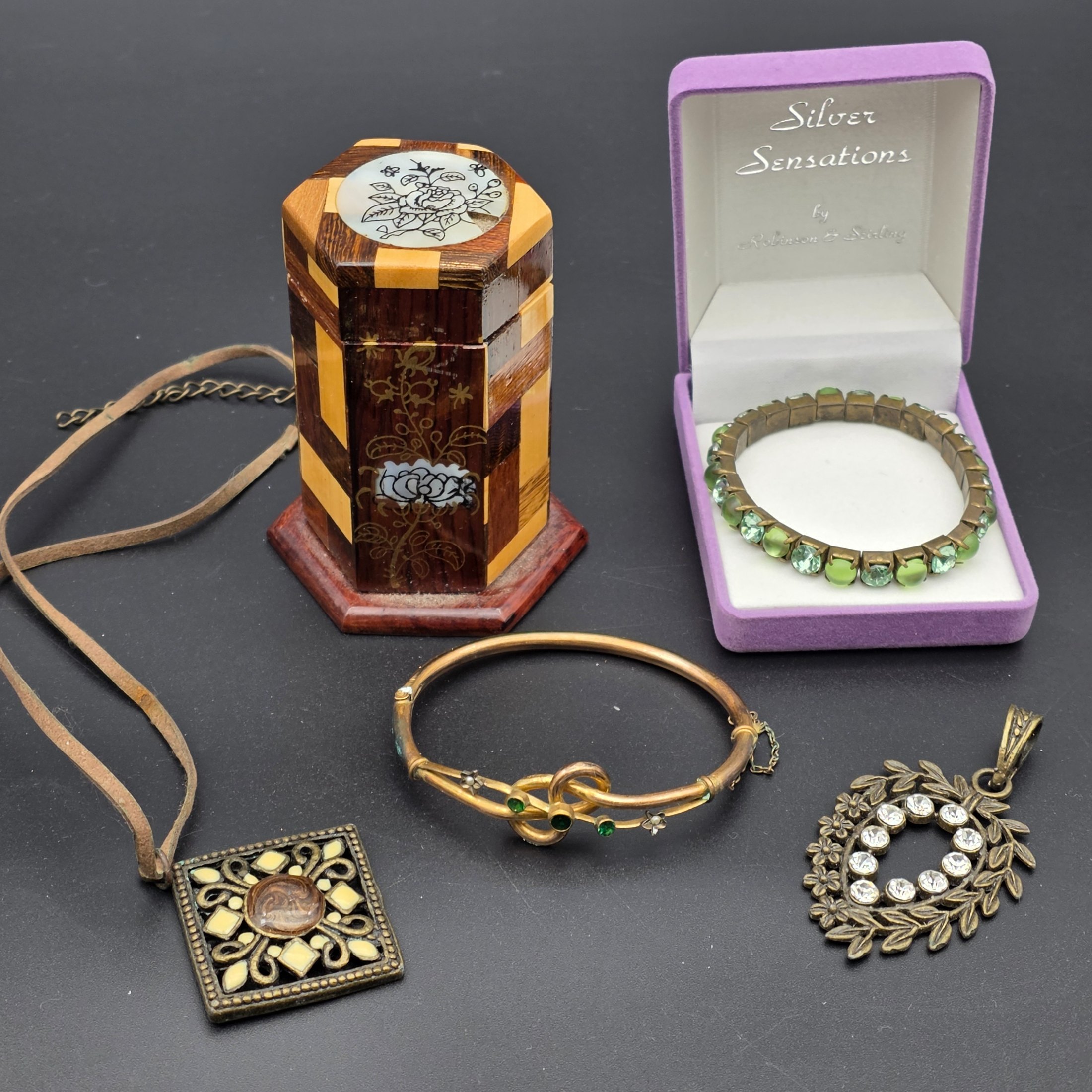 A diverse lot of vintage decorative sundries, featuring costume jewellery and a unique inlaid wooden box, offering a varied collection for enthusiasts of vintage accessories.