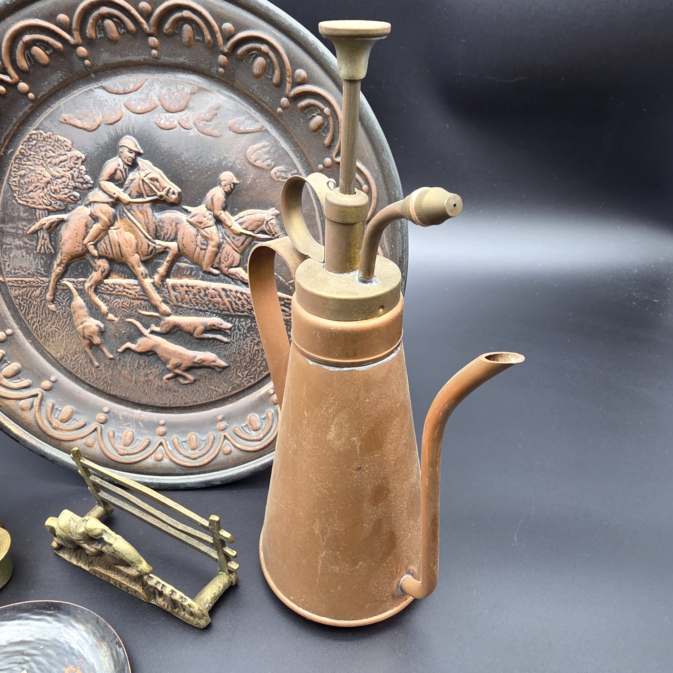 A curated collection of vintage metallic decorative sundries, primarily crafted from brass and copper, spanning mid to late 20th-century origins, including an embossed wall plate, a plant mister, letter holder, ashtrays, a vase, and a small dish. - View 2
