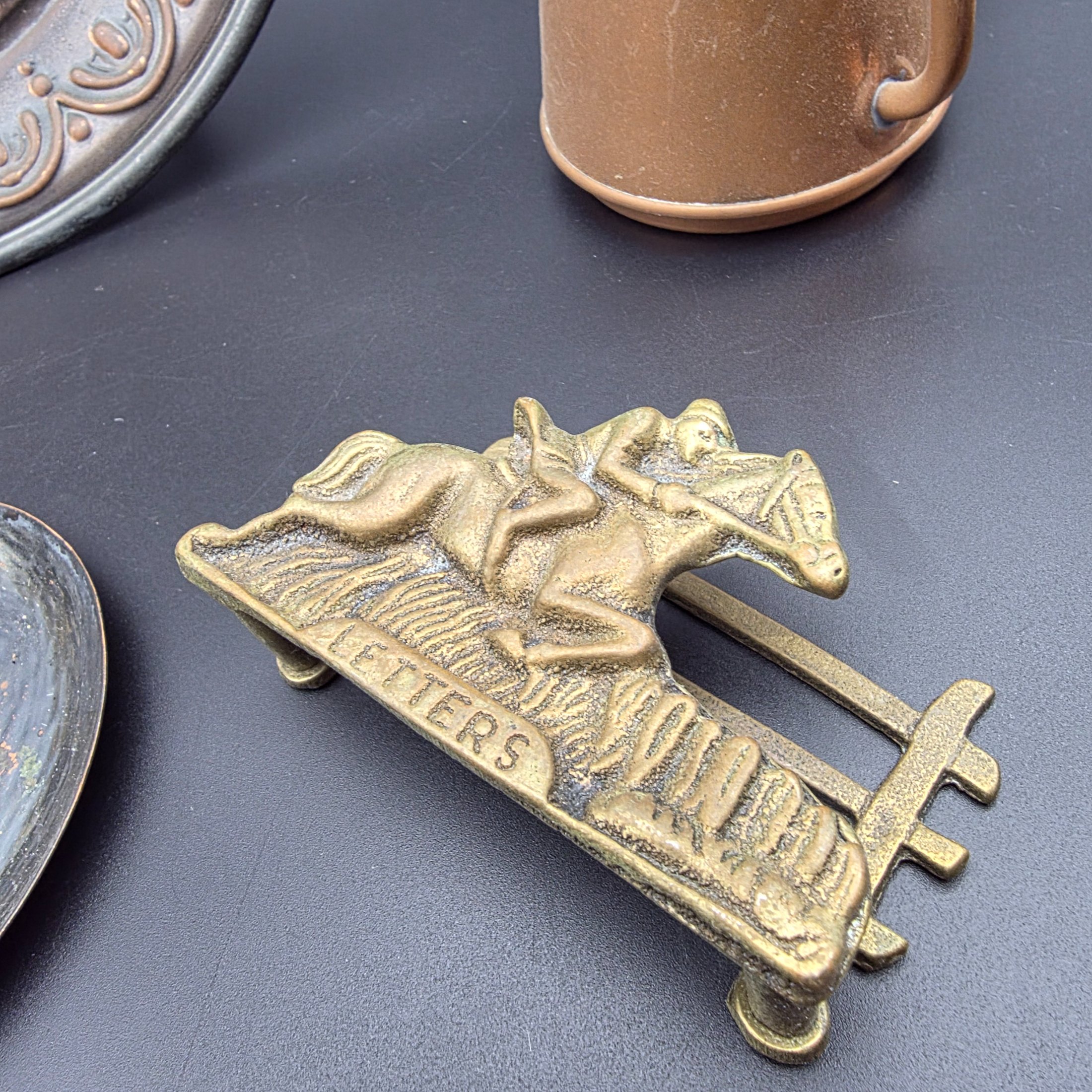 A curated collection of vintage metallic decorative sundries, primarily crafted from brass and copper, spanning mid to late 20th-century origins, including an embossed wall plate, a plant mister, letter holder, ashtrays, a vase, and a small dish. - View 4