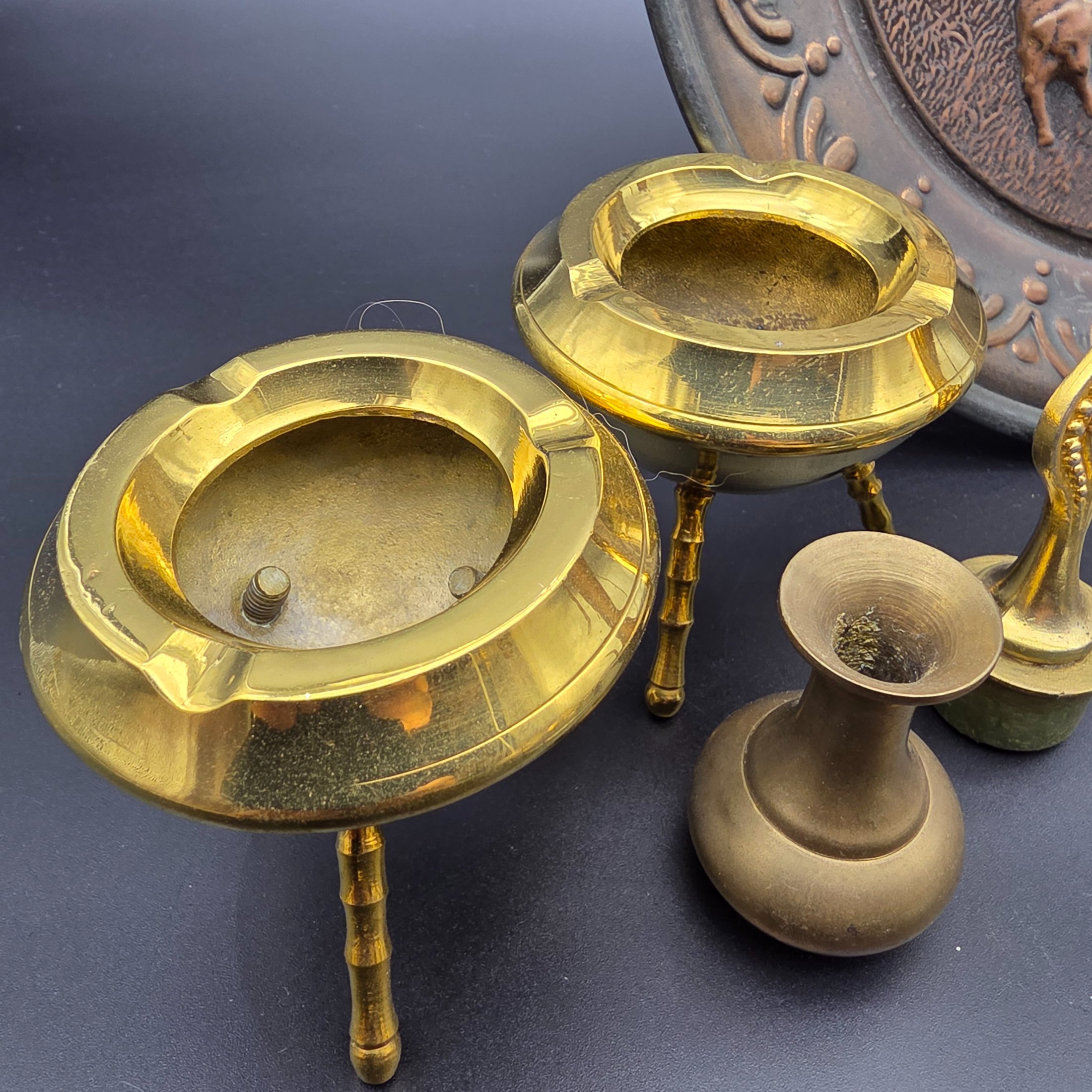 A curated collection of vintage metallic decorative sundries, primarily crafted from brass and copper, spanning mid to late 20th-century origins, including an embossed wall plate, a plant mister, letter holder, ashtrays, a vase, and a small dish. - View 8