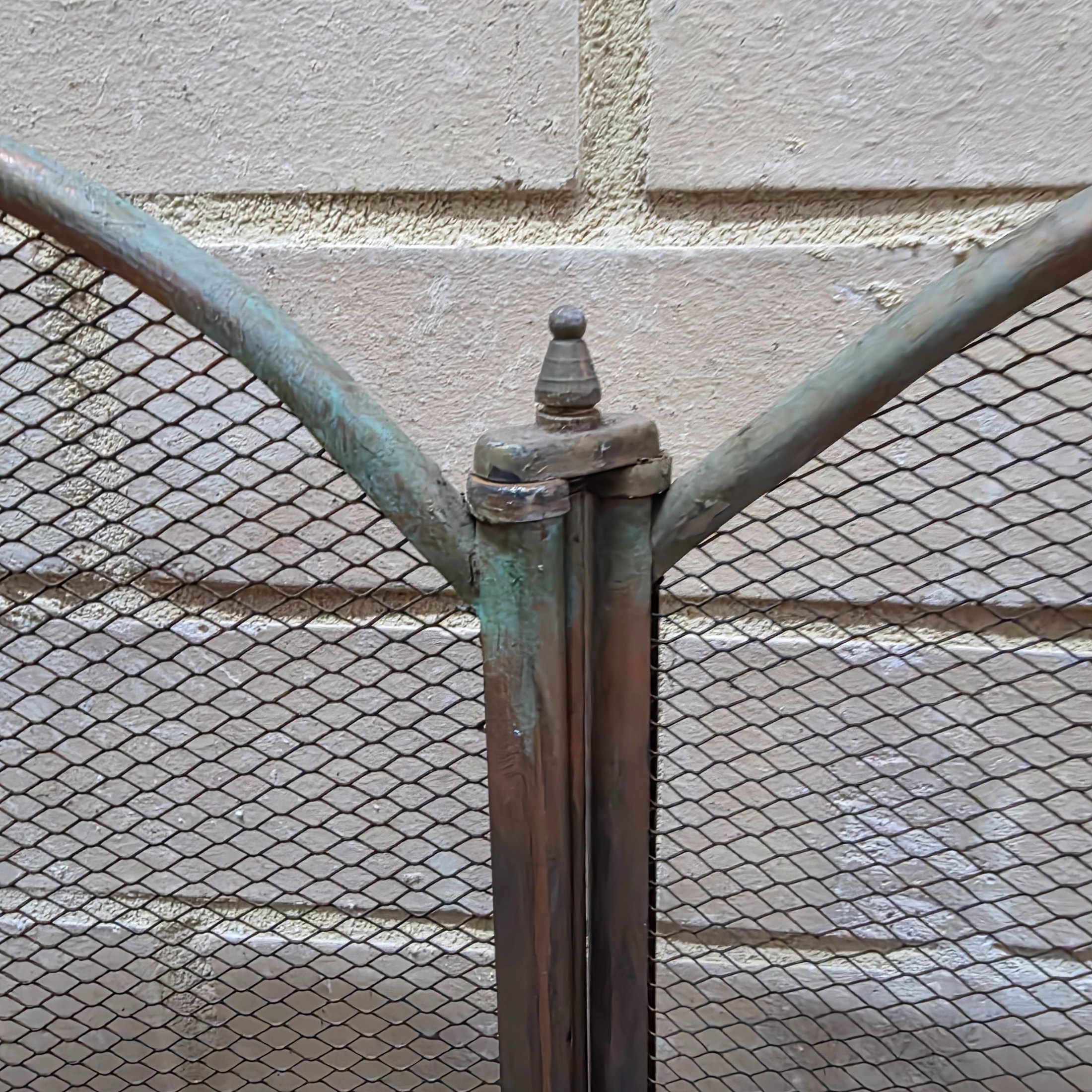 A vintage four-panel brass and mesh fireplace screen, designed to protect from sparks while adding decorative appeal to a hearth. - View 3