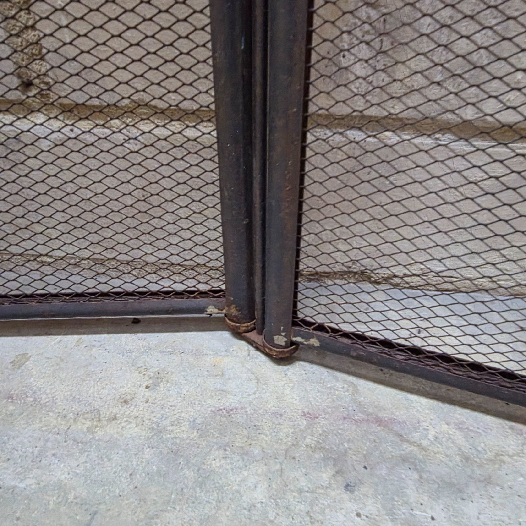 A vintage four-panel brass and mesh fireplace screen, designed to protect from sparks while adding decorative appeal to a hearth. - View 5