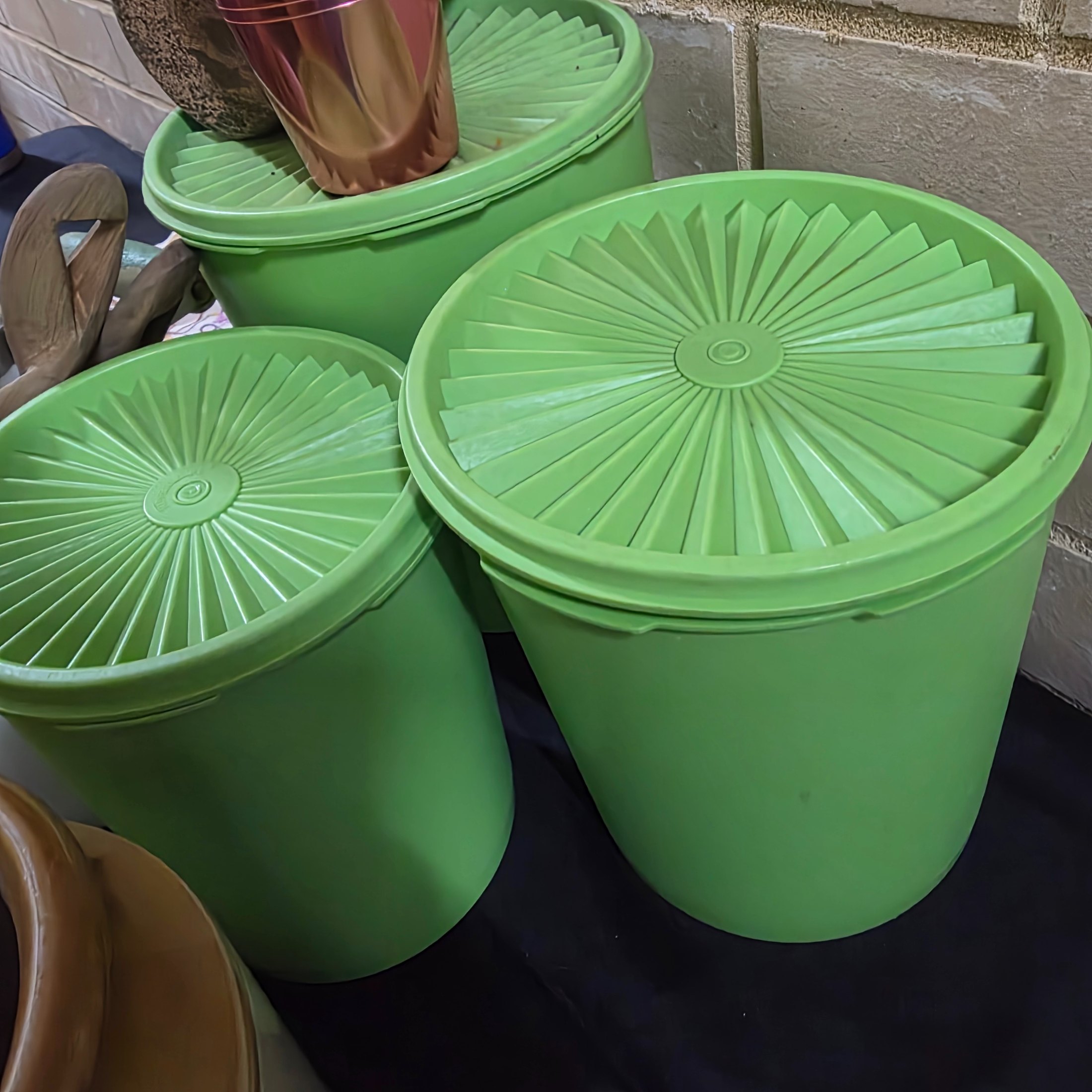 A diverse collection of vintage homewares and kitchen items including cast iron pans, a hand mixer, Tupperware, ceramic crocks, aluminium cups, and various other utensils and decorative pieces. - View 4