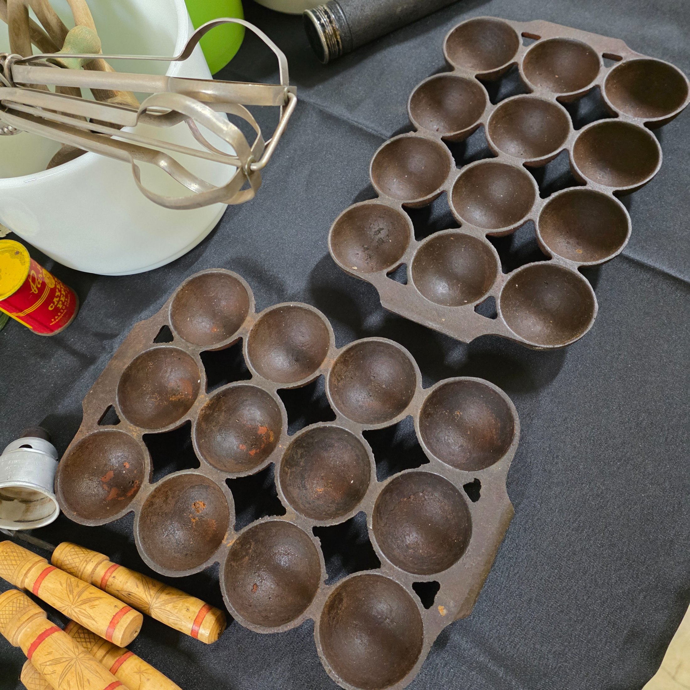 A diverse collection of vintage homewares and kitchen items including cast iron pans, a hand mixer, Tupperware, ceramic crocks, aluminium cups, and various other utensils and decorative pieces. - View 6