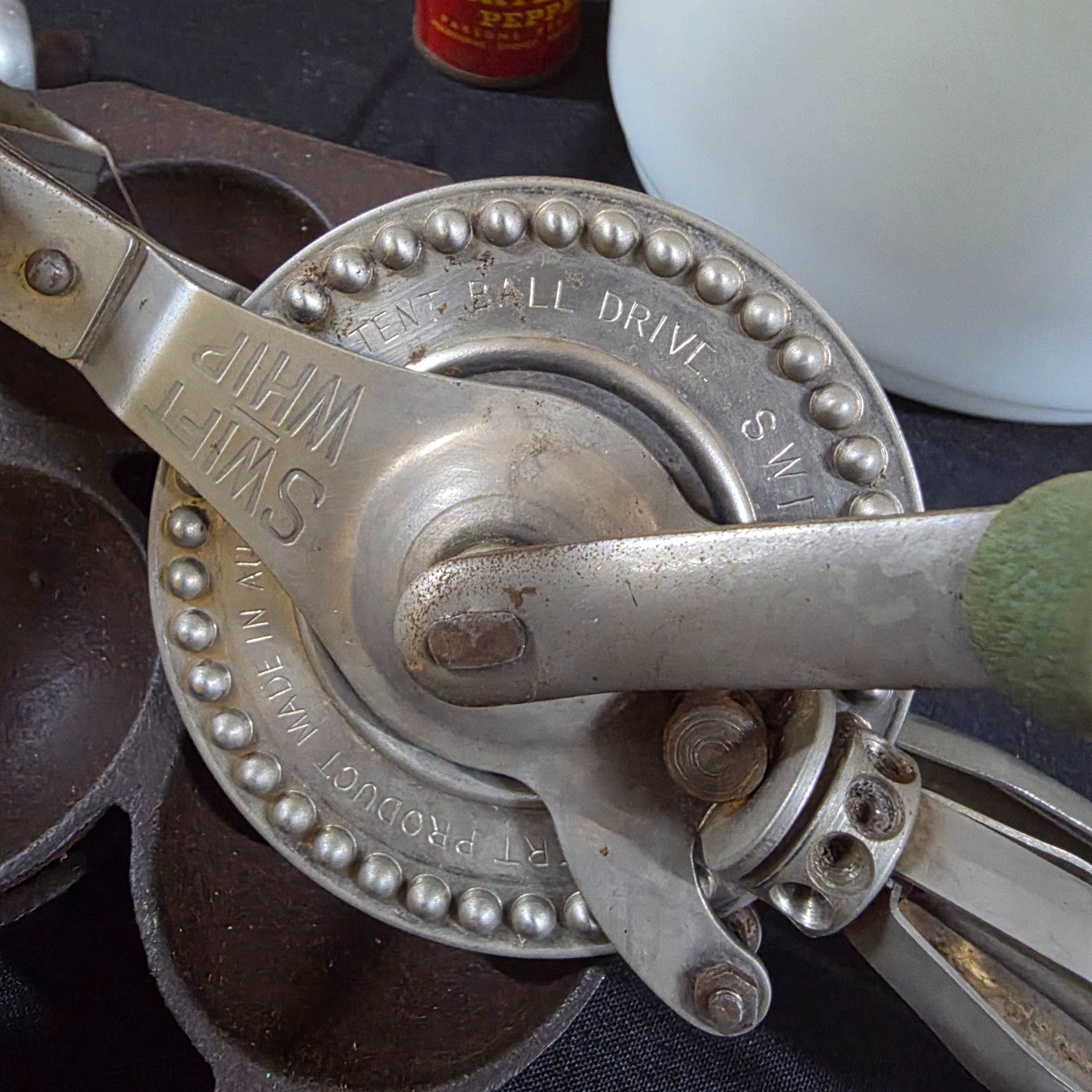 A diverse collection of vintage homewares and kitchen items including cast iron pans, a hand mixer, Tupperware, ceramic crocks, aluminium cups, and various other utensils and decorative pieces. - View 8