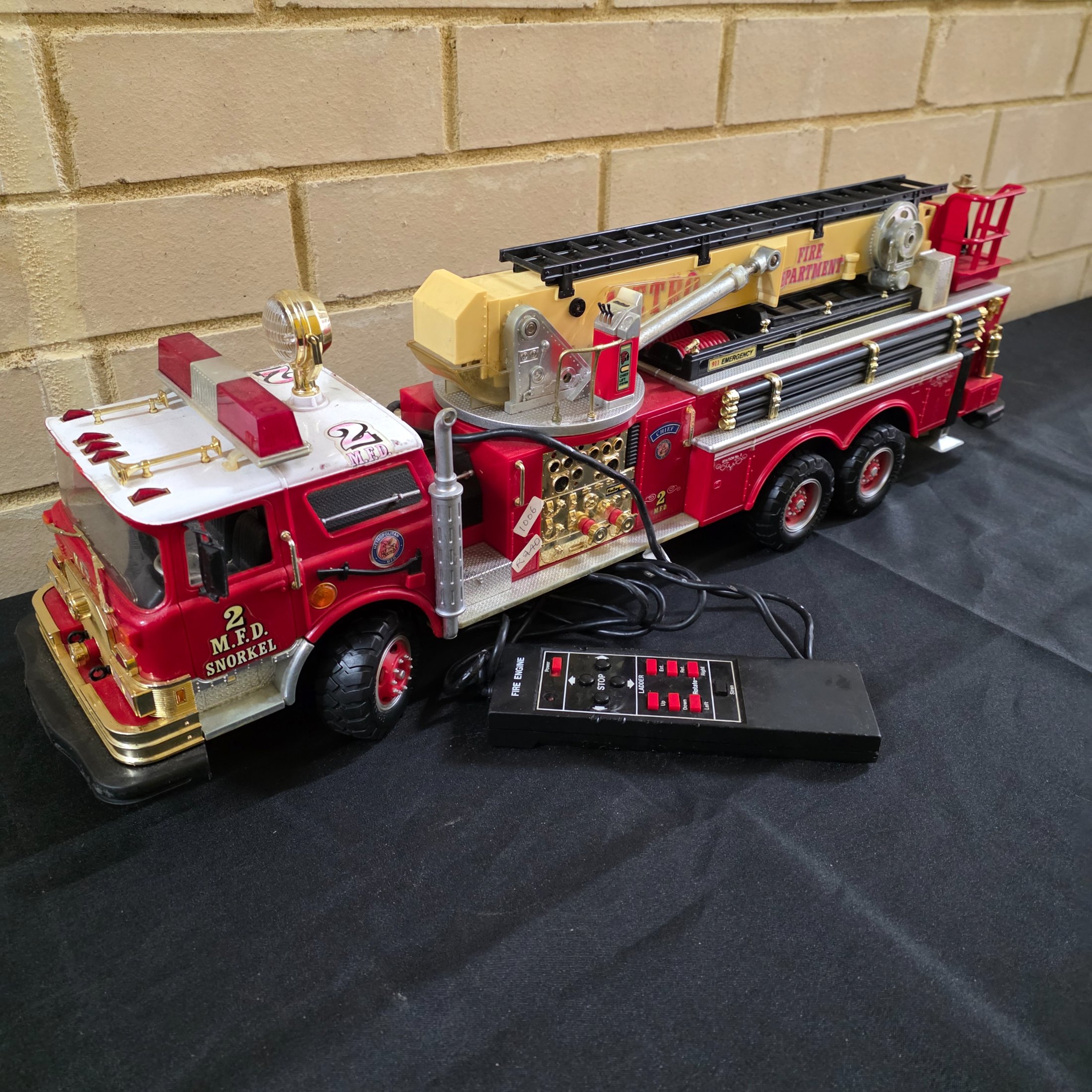 A vintage New Bright remote control toy fire engine, dating from around 1990, constructed from plastic and metal components.