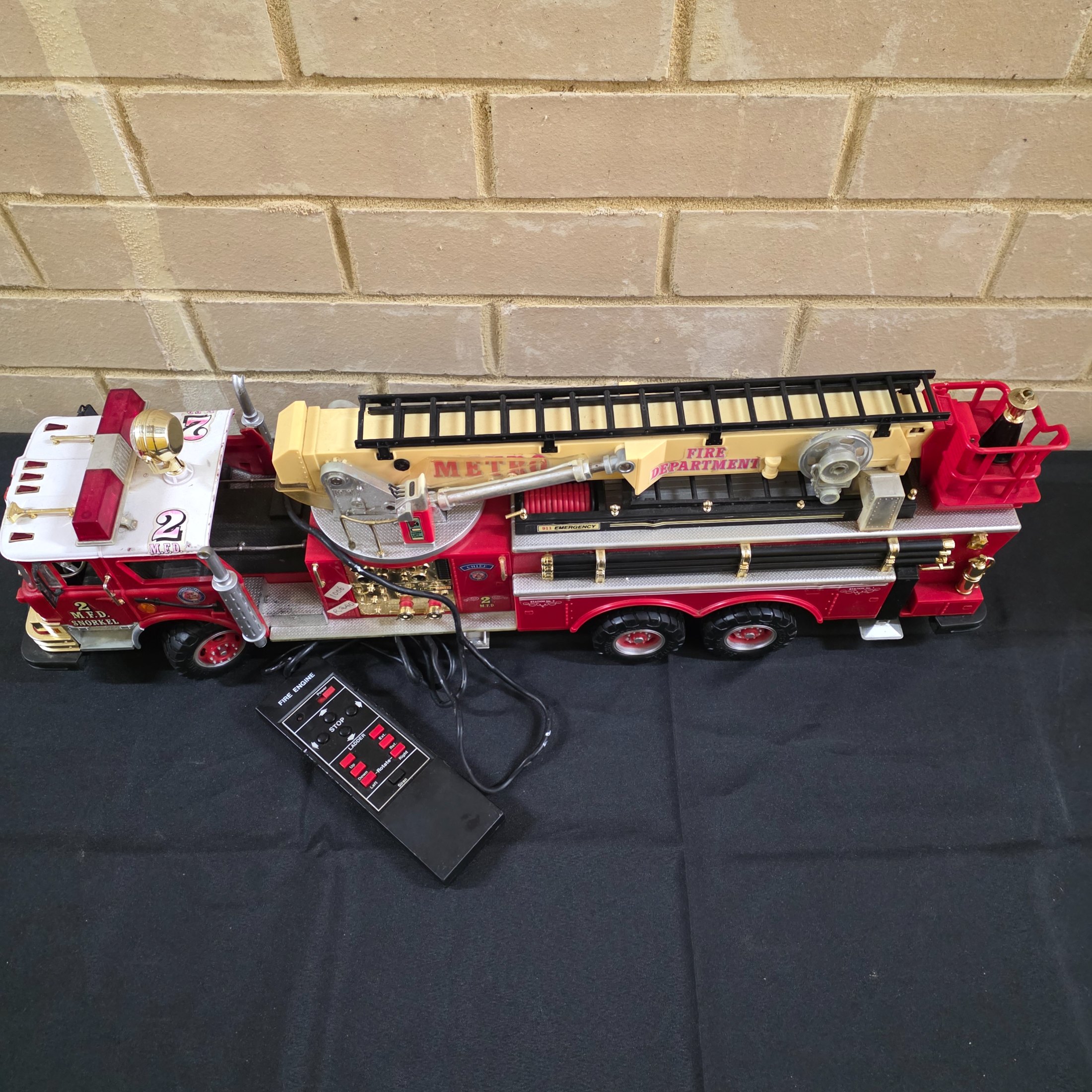 A vintage New Bright remote control toy fire engine, dating from around 1990, constructed from plastic and metal components. - View 2