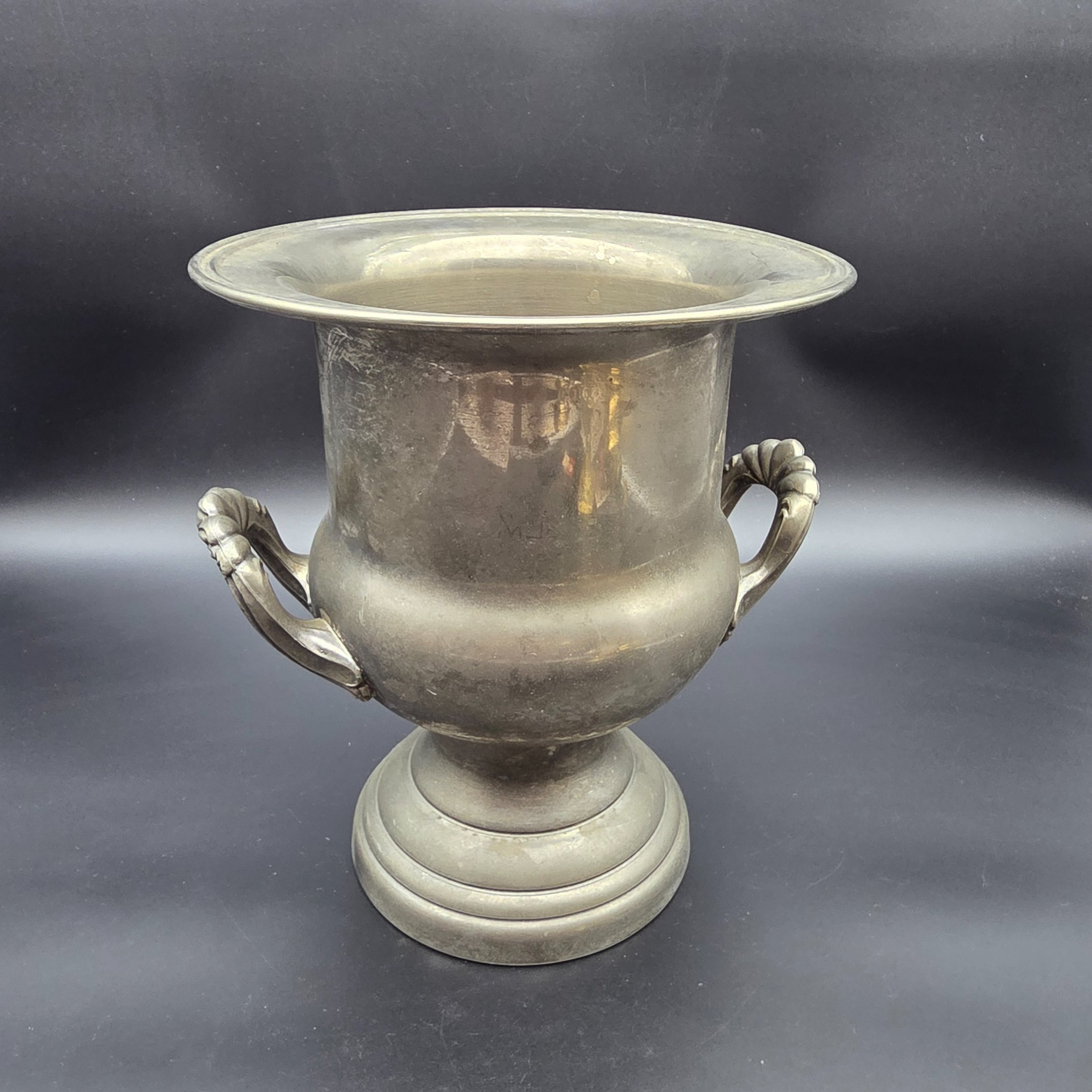 A vintage pewter commemorative urn from the late 20th or early 21st century, featuring a classic pedestal design, two ornate twisted handles, and a flared rim.