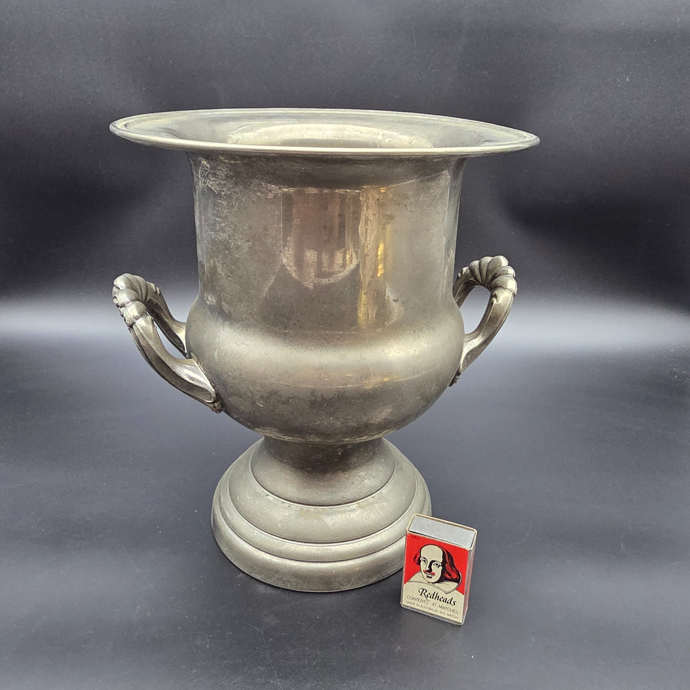 A vintage pewter commemorative urn from the late 20th or early 21st century, featuring a classic pedestal design, two ornate twisted handles, and a flared rim. - View 2