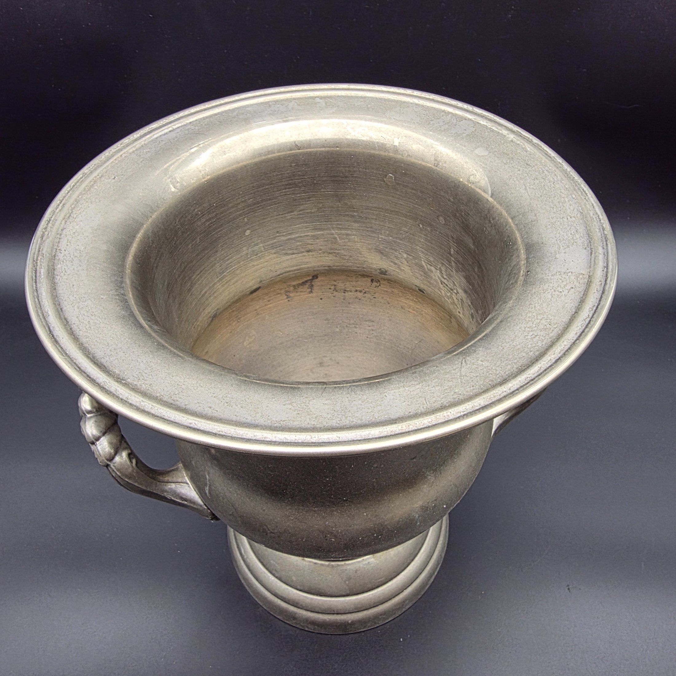 A vintage pewter commemorative urn from the late 20th or early 21st century, featuring a classic pedestal design, two ornate twisted handles, and a flared rim. - View 3