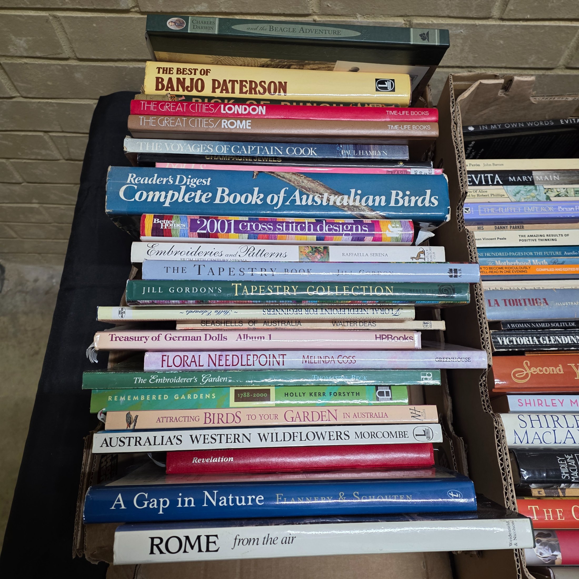 A diverse collection of pre-owned books spanning various genres, including fiction, non-fiction, nature, craft, and history, presented in several cardboard boxes. - View 2