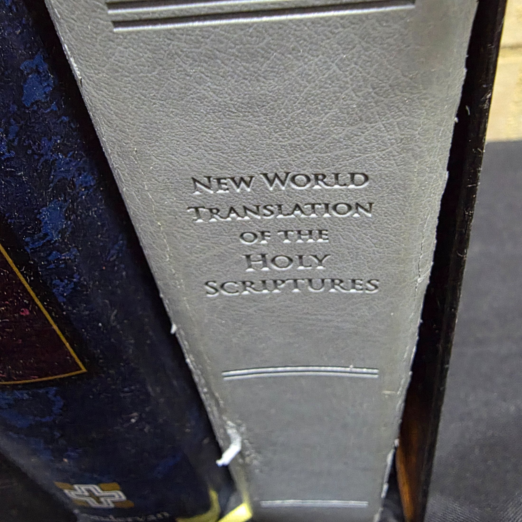 A large collection of mixed religious books and Bibles, including various translations, study guides, and annual publications, presented in a cardboard box and arranged on a surface. - View 5